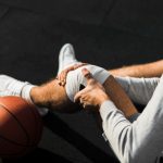 basketball-player-applying-bandage-knee
