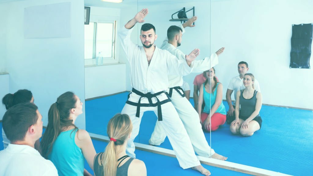 Male Martial arts instructor shows the techniques of adult students in the classroom